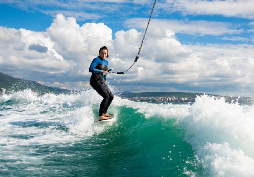athletic-woman-wakesurfing-on-the-board-on-lake-2021-11-09-18-05-53-utc-scaled.jpg